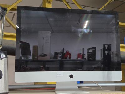 un écran d'ordinateur posé sur un bureau, à côté d'un mixeur