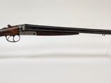 un fusil au canon en bois posé sur un socle en acrylique transparent