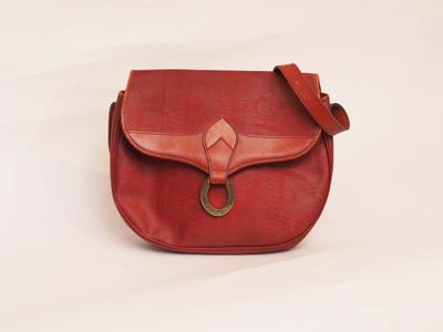 red leather purse with a metal ring on the front