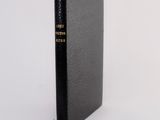 a black book sitting on top of a white surface