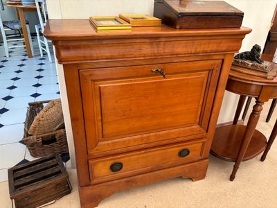 une petite armoire en bois surmontée d'un miroir