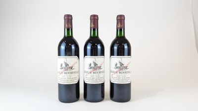 trois bouteilles de vin posées les unes à côté des autres sur une surface blanche