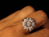 a woman ' s hand with a diamond ring on it
