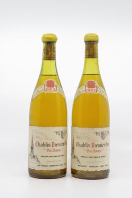 two bottles of wine sitting next to each other on a white surface