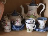 a shelf that has a bunch of cups and saucers on it
