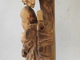 carved wooden sculpture of a man and a woman holding a baby