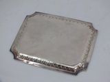 a silver tray on a white table with a silver handle