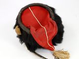 a red and black hat with a tassel on it