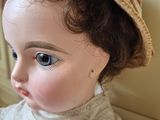 a close up of a doll with a hat on
