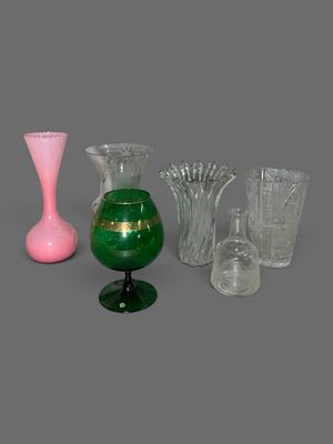 plusieurs vases en verre de différentes couleurs posés sur une surface grise