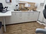 a desk with a laptop and a chair in a room