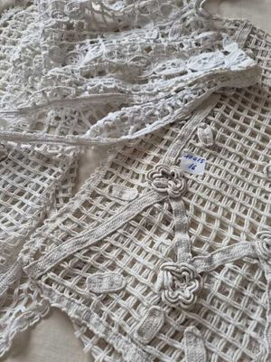 a close up of a white crochet with a flower on it