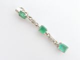 un gros plan sur un bracelet en émeraude verte et diamants