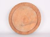 a wooden plate on a white surface with a white background