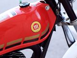 a close up of a red motorcycle parked on the side of the road