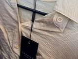 the shirt is white and has a black tag on it