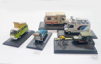 four model cars and a van on display on a table