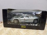 silver model of a sports car in a box on a table