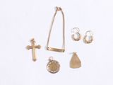 an assortment of gold jewelry including a cross, a necklace, and earrings
