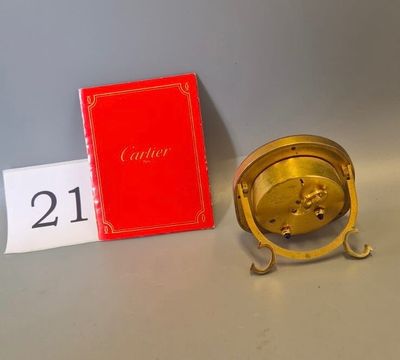 a gold clock sitting next to a red book