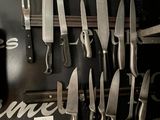 beaucoup de couteaux accrochés au mur de la cuisine