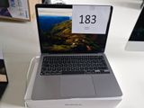 un ordinateur portable posé sur une table blanche