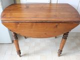 a small table with a wooden top on a tile floor