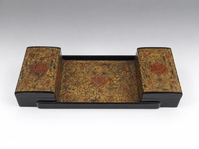 un plateau noir et doré orné d'un motif floral