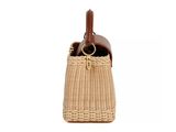 the small woven bag has a brown handle and a brown strap
