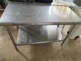 a stainless steel table with a shelf underneath it