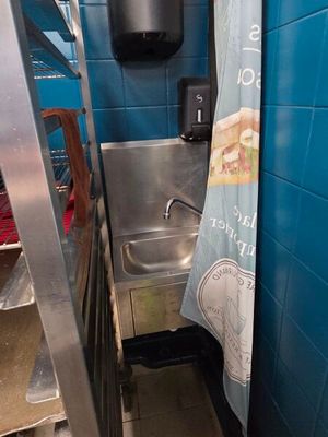 a blue tiled bathroom with a stainless steel sink and a blue towel hanging from the wall