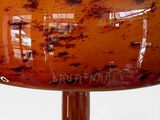 a large glass vase with a brown base on a table