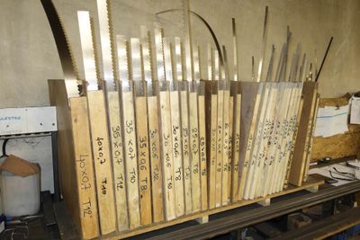 Dans un atelier, plusieurs morceaux de bois sont empilés les uns sur les autres