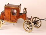 a small wooden horse drawn carriage on a white surface