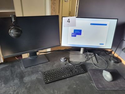 deux écrans d'ordinateur et un clavier sur un bureau