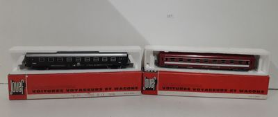 two red and black train cars sitting next to each other on a table