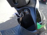 a black scooter parked on the side of the street