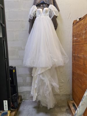 a wedding dress hanging on a wall in a room