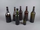six bouteilles de vin sont alignées sur une surface grise