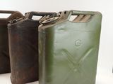 three green jerry cans sitting next to each other on a white surface
