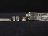a small glass bottle with a small metal object inside of it