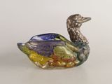 un canard en verre posé sur une table blanche