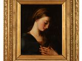 un tableau représentant une femme les mains jointes, dans un cadre doré
