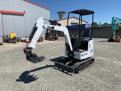a small excavating machine parked in front of a building