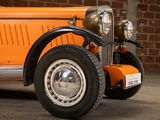 an orange car parked in front of a brick wall