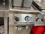 une cuisine avec de nombreux éléments en inox sur le plan de travail