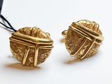 une paire de boucles d'oreilles dorées ornées d'un nœud à chaque extrémité