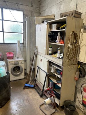 a dirty kitchen with a washer and dryer in it