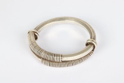 a close up of a silver bracelet on a white surface