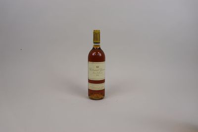 une photo d'une bouteille de vin posée sur une surface blanche